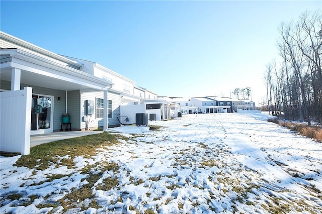 yard layered in snow with central AC unit