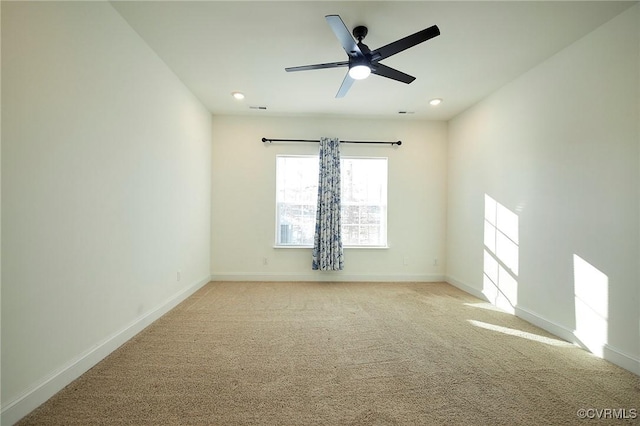 spare room featuring light colored carpet and ceiling fan