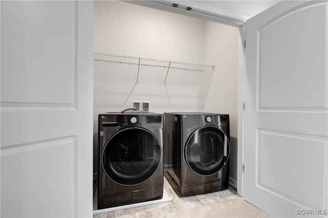 clothes washing area with separate washer and dryer