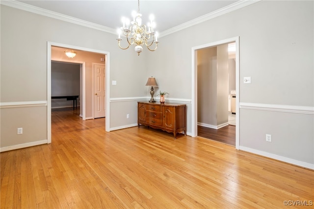 unfurnished dining area with ornamental molding, a chandelier, and light hardwood / wood-style floors