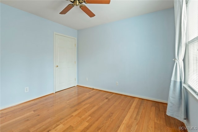 empty room featuring ceiling fan, light hardwood / wood-style floors, and a healthy amount of sunlight