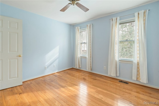 spare room with ceiling fan, light hardwood / wood-style floors, and a healthy amount of sunlight