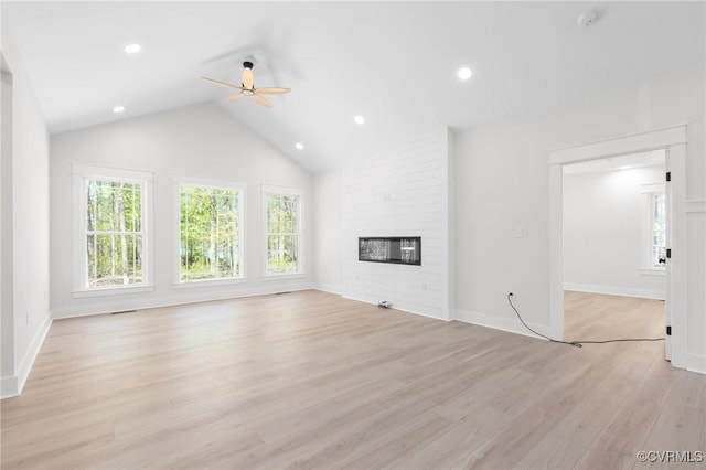 unfurnished living room with light wood-style flooring, vaulted ceiling, recessed lighting, a ceiling fan, and a fireplace