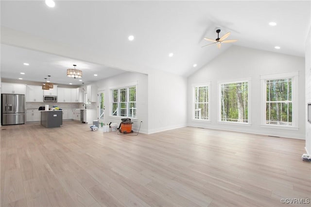 unfurnished living room featuring ceiling fan, lofted ceiling, light wood-style floors, and recessed lighting