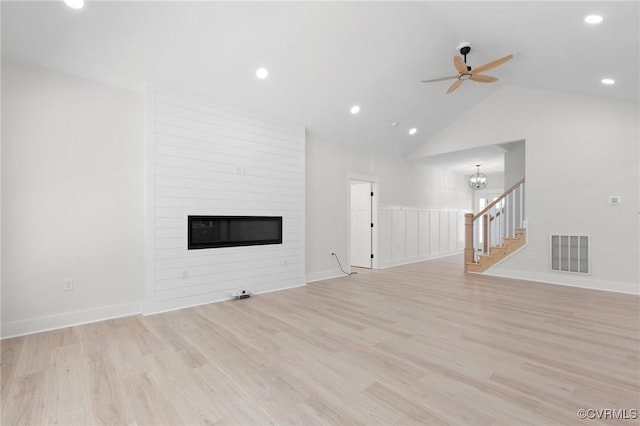 unfurnished living room with stairway, light wood-style flooring, visible vents, and ceiling fan with notable chandelier