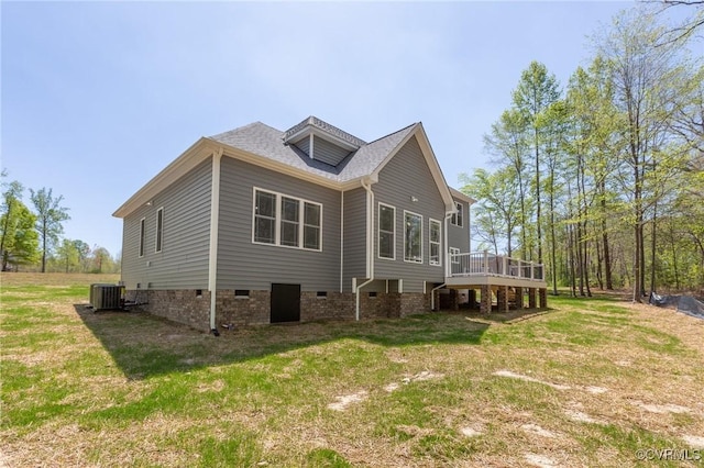 rear view of property featuring a lawn, central air condition unit, and a deck