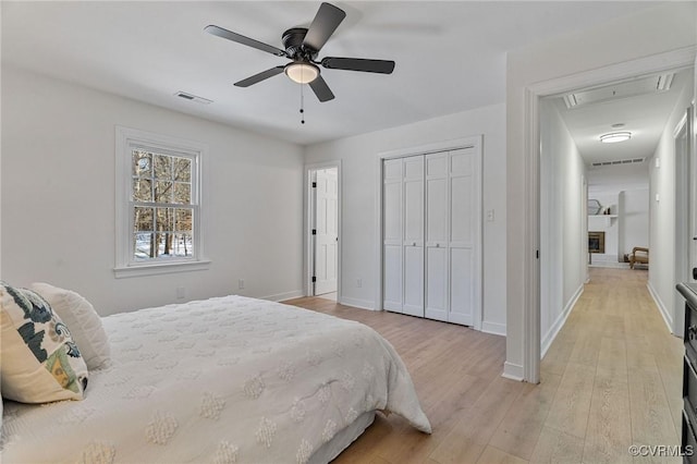 bedroom with a closet, ceiling fan, and light hardwood / wood-style flooring