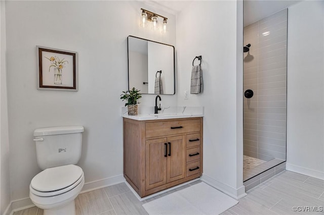 bathroom with tile patterned floors, a tile shower, vanity, and toilet