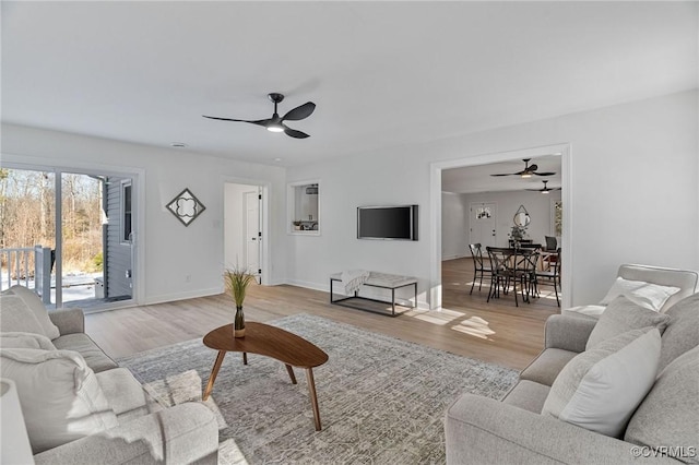 living room with light wood-type flooring and ceiling fan