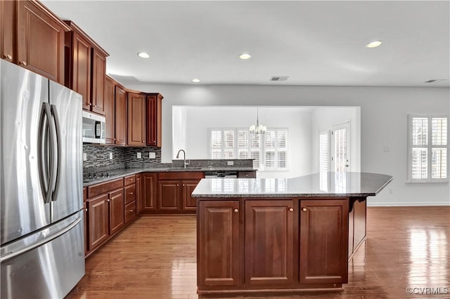 kitchen with sink, stainless steel appliances, a center island, and plenty of natural light