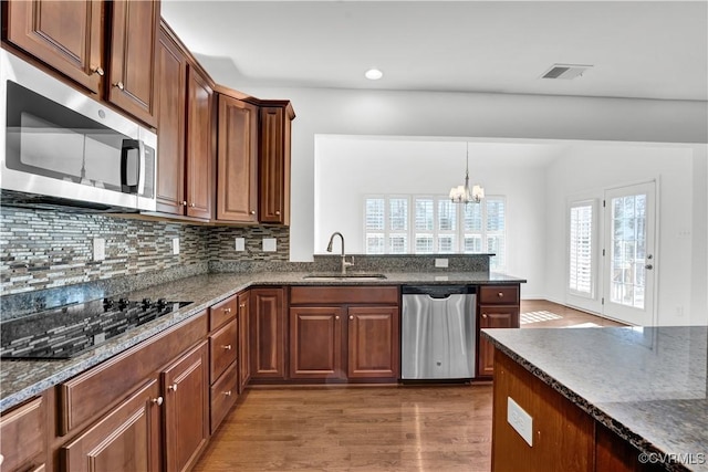 kitchen with sink, stainless steel appliances, an inviting chandelier, and dark wood-type flooring