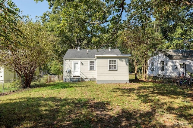 rear view of house featuring a yard