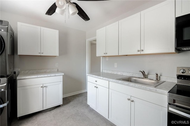 kitchen with stacked washing maching and dryer, white cabinetry, electric range, and sink