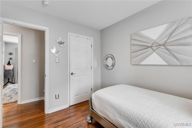 bedroom with dark hardwood / wood-style floors