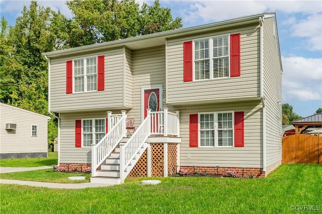 split foyer home with a wall unit AC and a front lawn