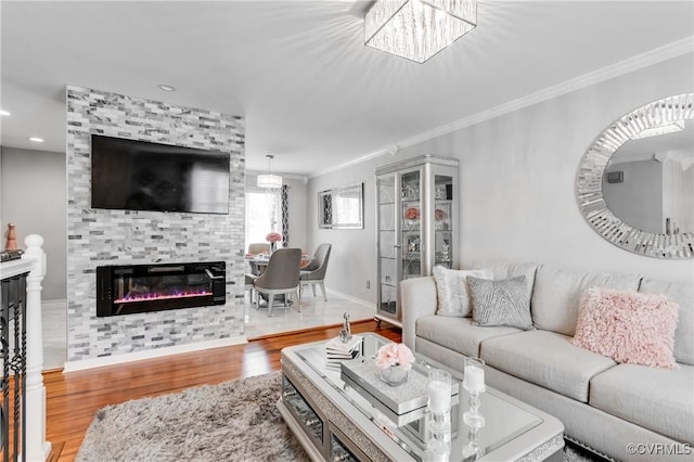 living room featuring a tiled fireplace, hardwood / wood-style floors, and crown molding