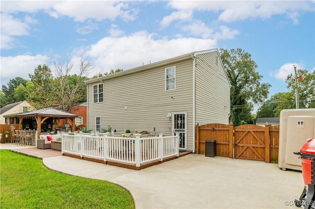 rear view of house with a yard, outdoor lounge area, a patio, and a gazebo