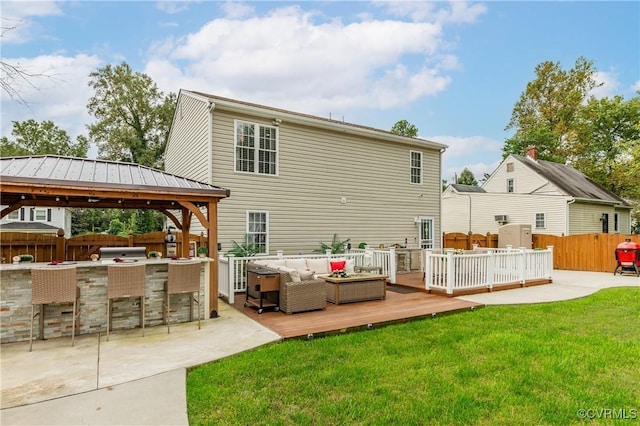 back of house featuring a deck, outdoor lounge area, an outdoor bar, a gazebo, and a yard