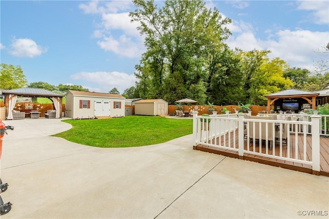 view of patio / terrace featuring a gazebo, a wooden deck, and a storage shed