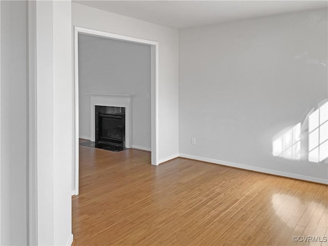 unfurnished living room with a premium fireplace and wood-type flooring