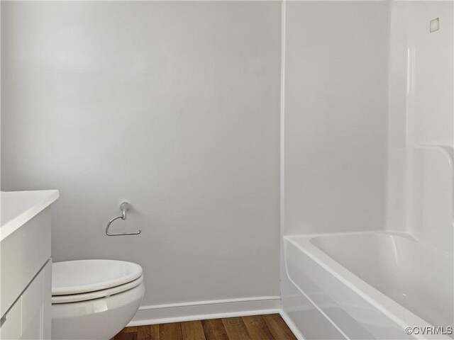 bathroom featuring toilet, hardwood / wood-style floors, and vanity