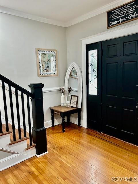 foyer featuring ornamental molding and hardwood / wood-style flooring