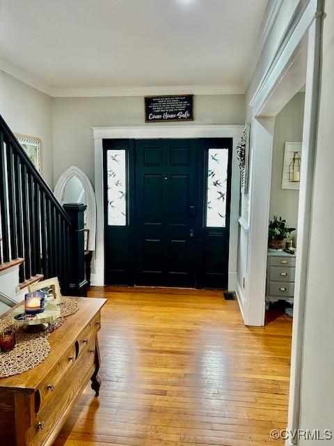 entryway featuring ornamental molding and light wood-type flooring