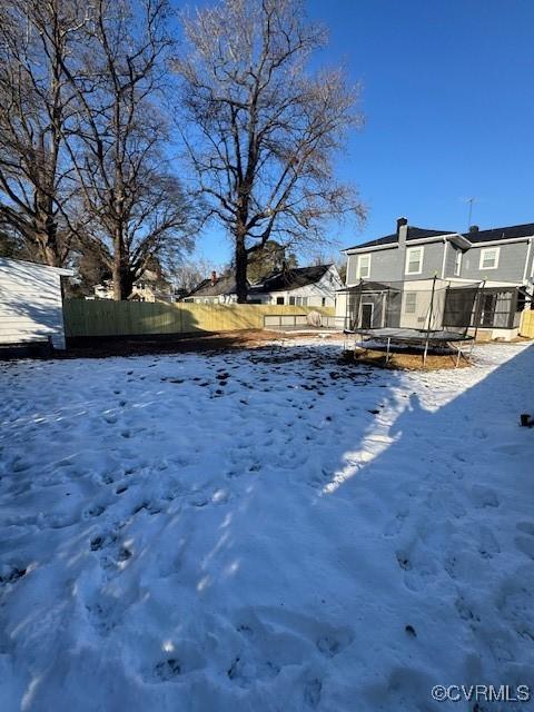 snowy yard with a trampoline