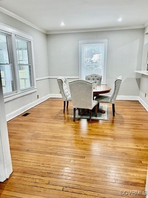 dining space featuring light hardwood / wood-style floors and ornamental molding