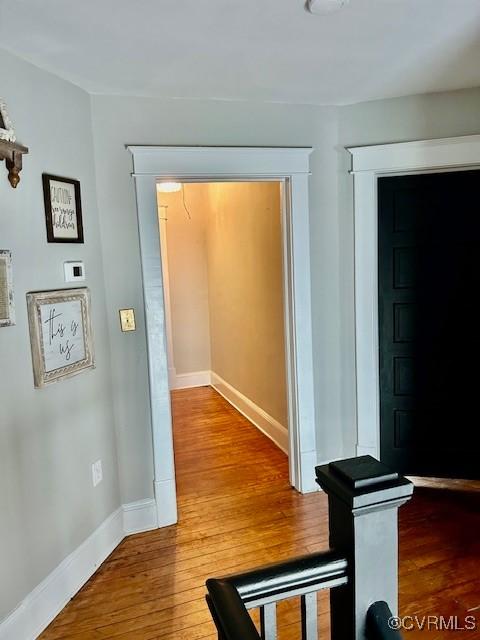 corridor with hardwood / wood-style flooring