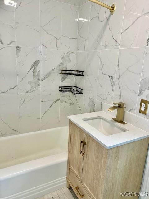 bathroom with tiled shower / bath and vanity