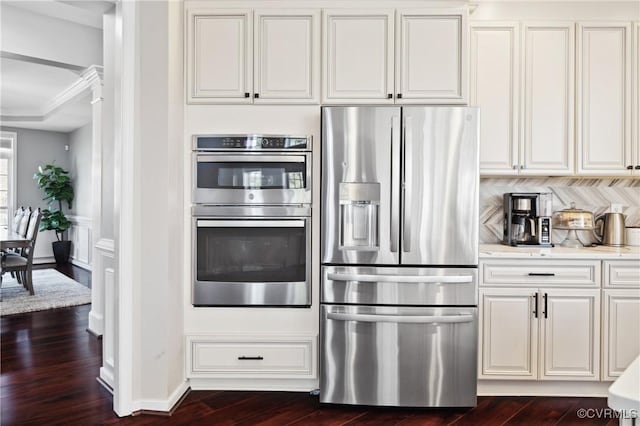 kitchen featuring stainless steel appliances, dark wood-type flooring, ornamental molding, and white cabinets