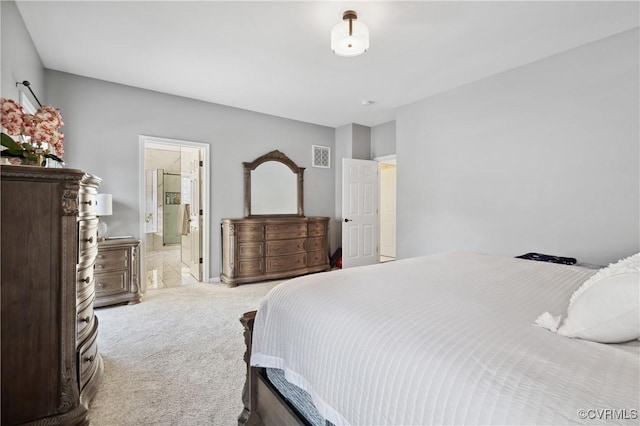 bedroom featuring ensuite bathroom and light carpet