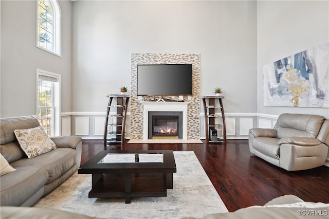 living room featuring dark wood-type flooring and a towering ceiling