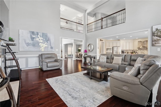 living room featuring a high ceiling and dark hardwood / wood-style floors