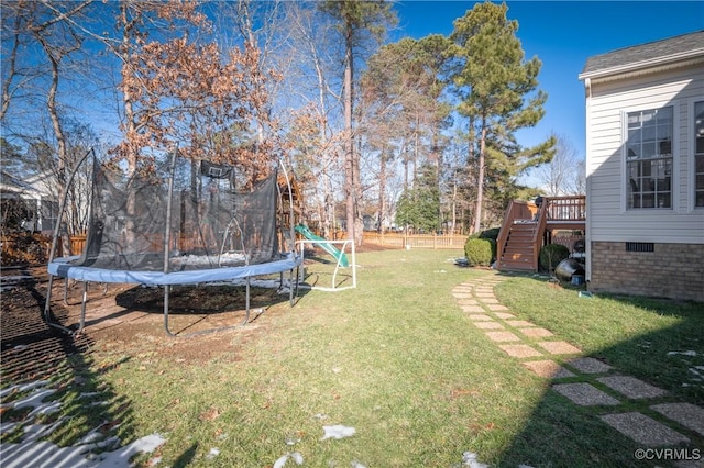 view of yard with a deck and a trampoline