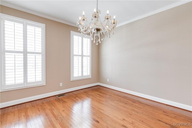 empty room with crown molding, plenty of natural light, and a notable chandelier