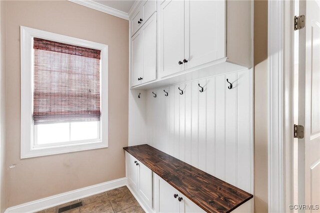 mudroom featuring light tile patterned floors and ornamental molding