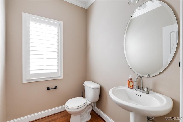 bathroom featuring toilet, ornamental molding, hardwood / wood-style floors, and sink