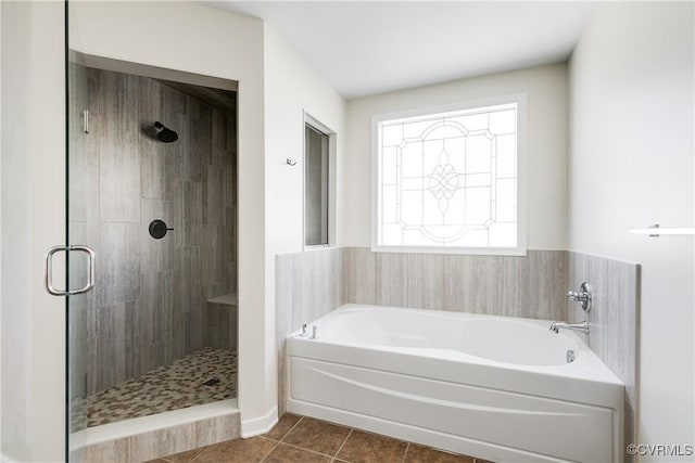 bathroom featuring a stall shower, tile patterned flooring, and a bath