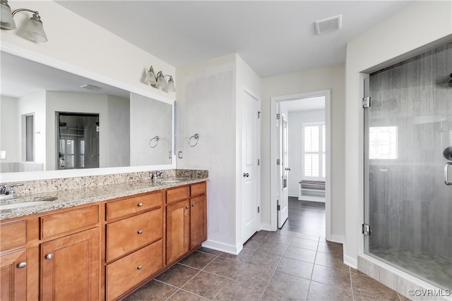 bathroom with walk in shower, vanity, and tile patterned flooring