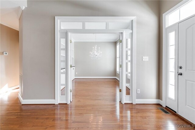 foyer featuring light hardwood / wood-style floors and an inviting chandelier