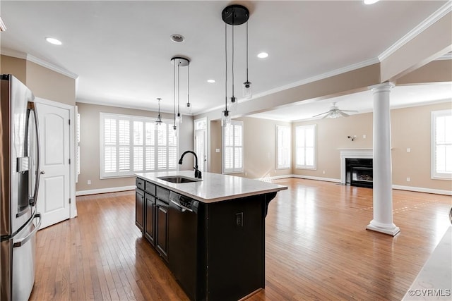 kitchen with black dishwasher, a center island with sink, light countertops, a sink, and stainless steel fridge with ice dispenser