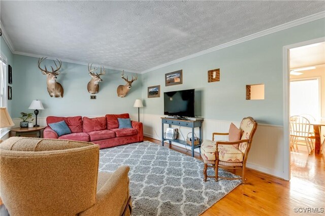 living room featuring a textured ceiling, hardwood / wood-style floors, and crown molding