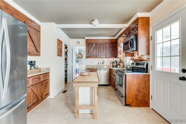 kitchen with ornamental molding and appliances with stainless steel finishes