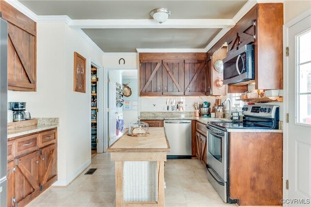 kitchen with stainless steel appliances and crown molding