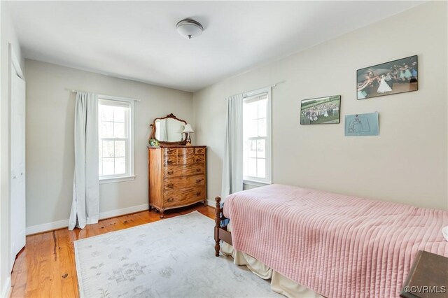 bedroom with hardwood / wood-style floors and multiple windows