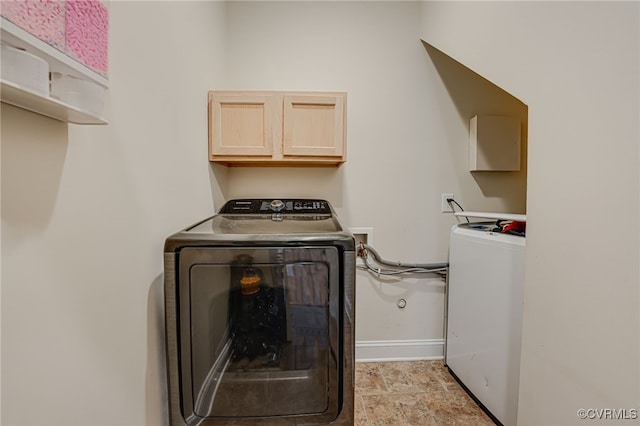 clothes washing area featuring cabinets