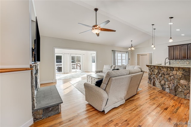 living room with ceiling fan, light wood-type flooring, lofted ceiling with beams, and sink