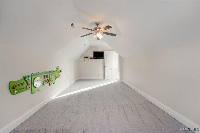 additional living space with lofted ceiling, ceiling fan, and light colored carpet